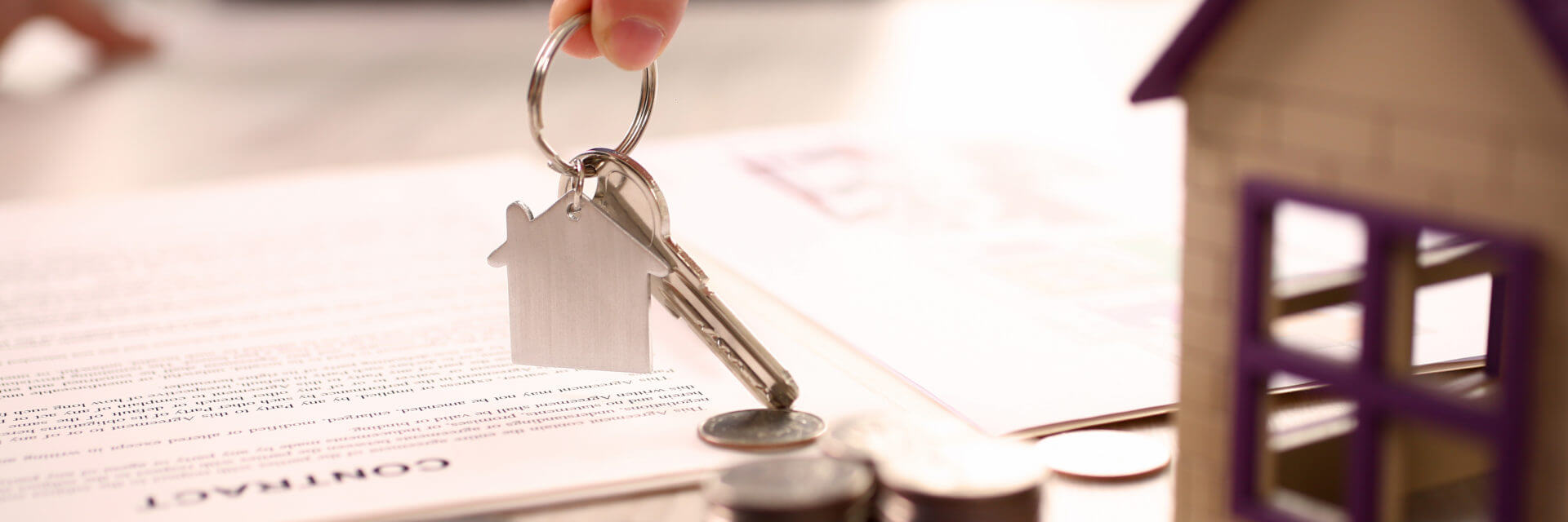 Keys being placed on a table with change and a contract