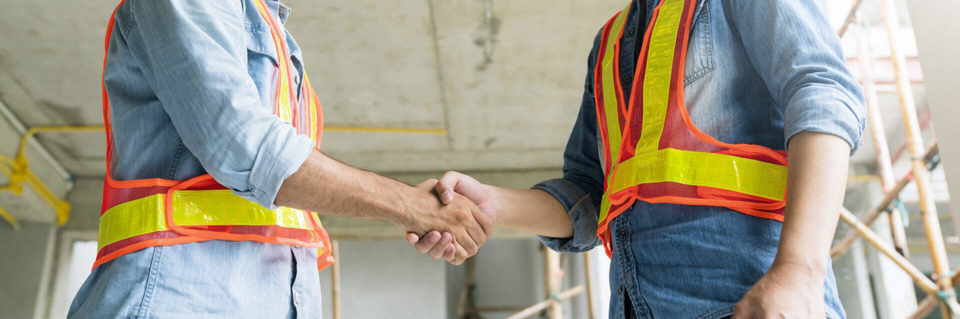 Men in construction vests shaking hands
